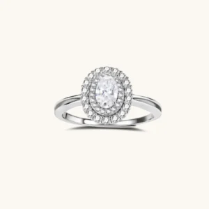 Collections Sterling silver ring with oval moissanite center stone surrounded by double halo of sparkling stones on neutral background.