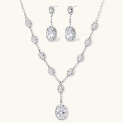 Elegant white gold plated jewelry set with oval cubic zirconia stones in halo settings, featuring Y-necklace and drop earrings.