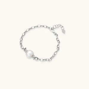 Collections Rhodium-plated silver chain bracelet with single white freshwater pearl and heart charm clasp on cream background