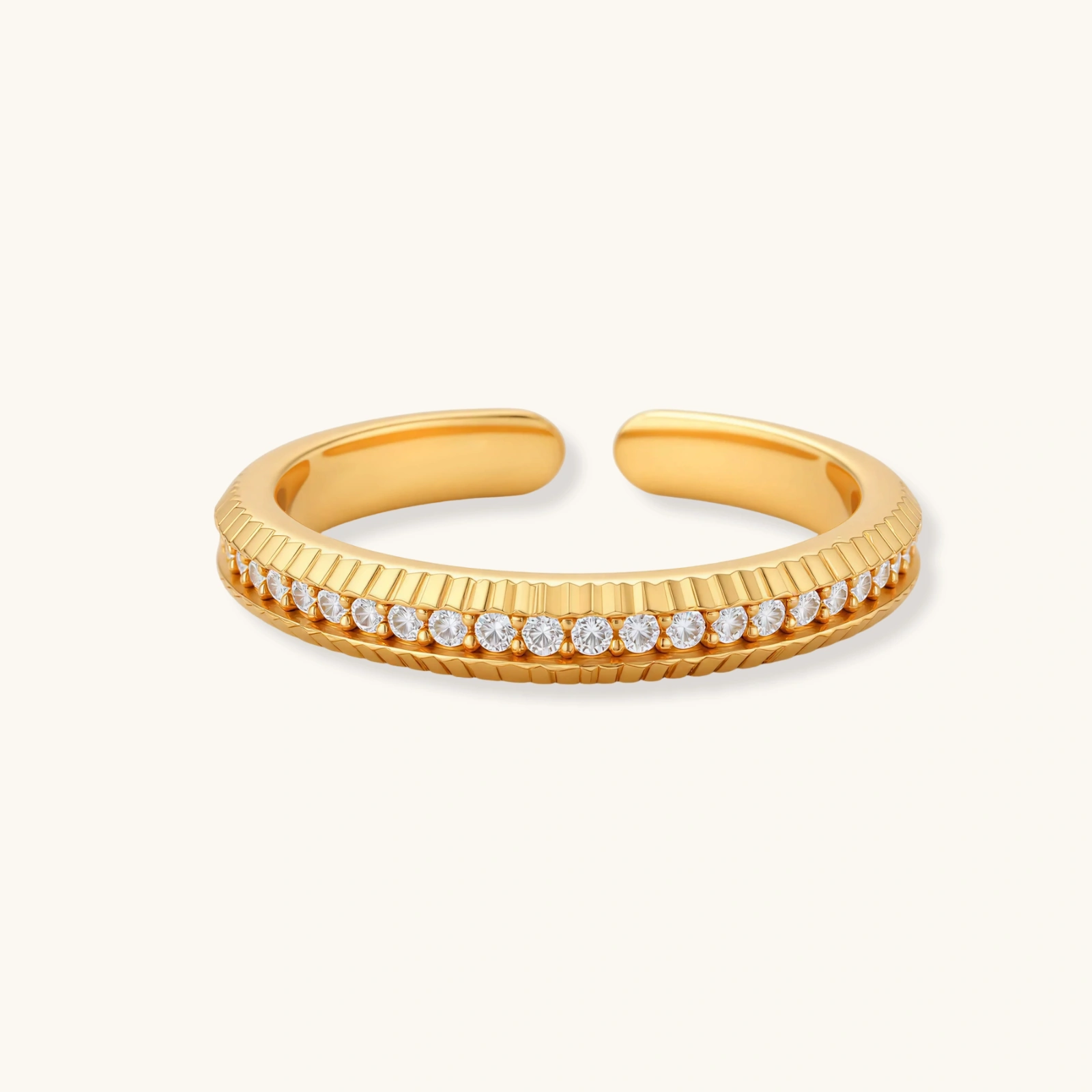 273951840097718272.webp Adjustable gold-plated ring with row of sparkling crystals on ribbed band, shot against cream background