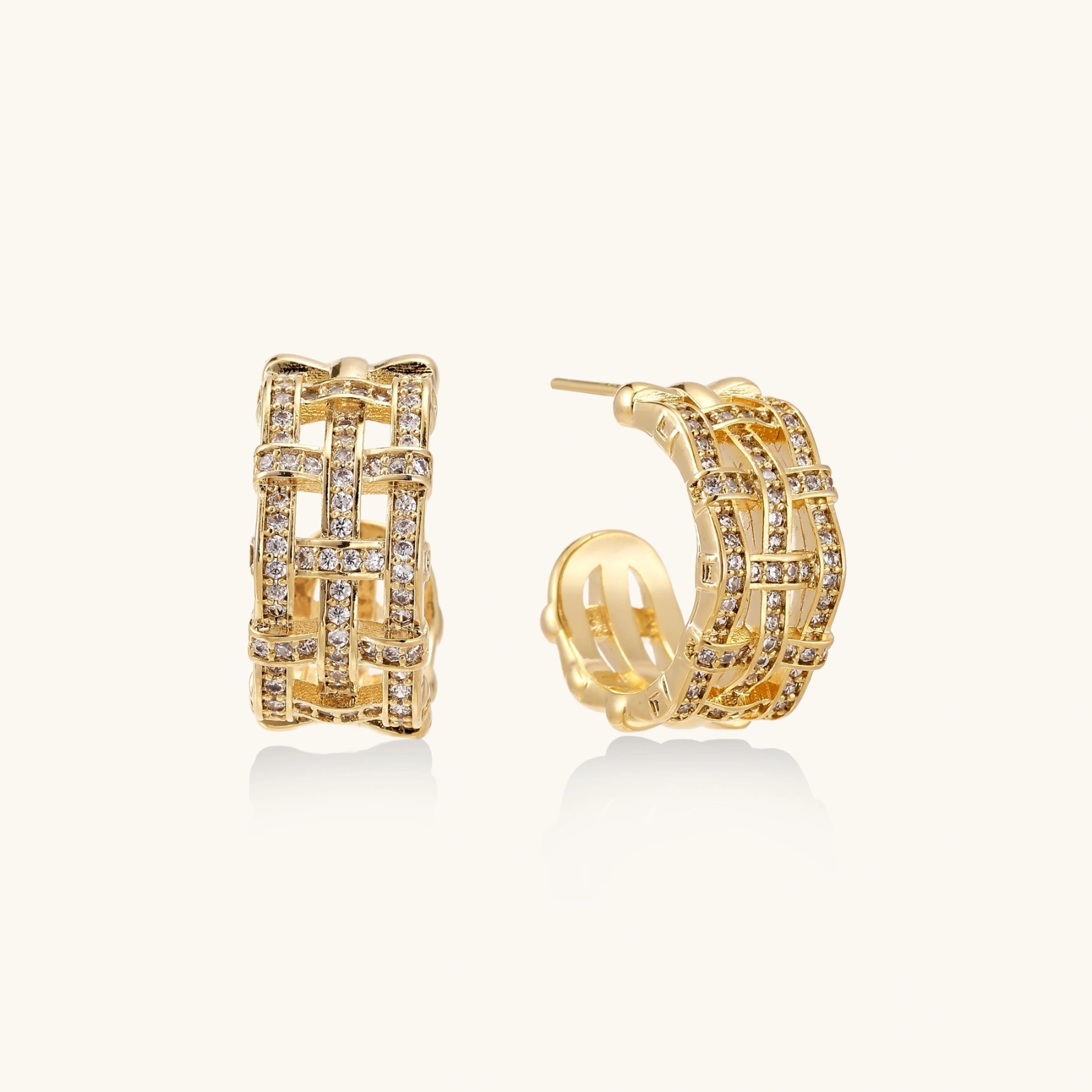 242422537267924992.webp Gold-plated geometric hoop earrings with basket-weave lattice design and pavé crystal accents on cream background